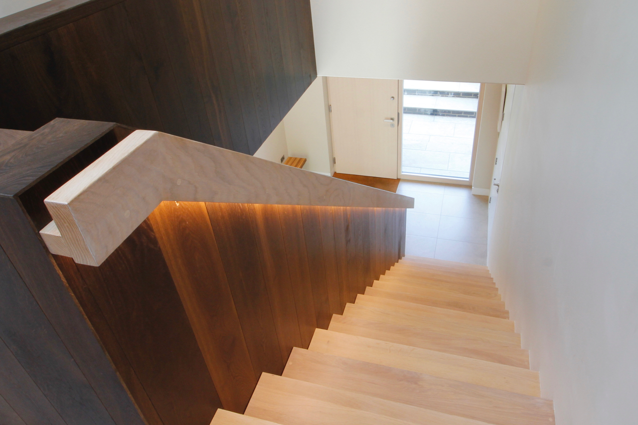 Dimmable LED lighting strip recessed under oak handrail.